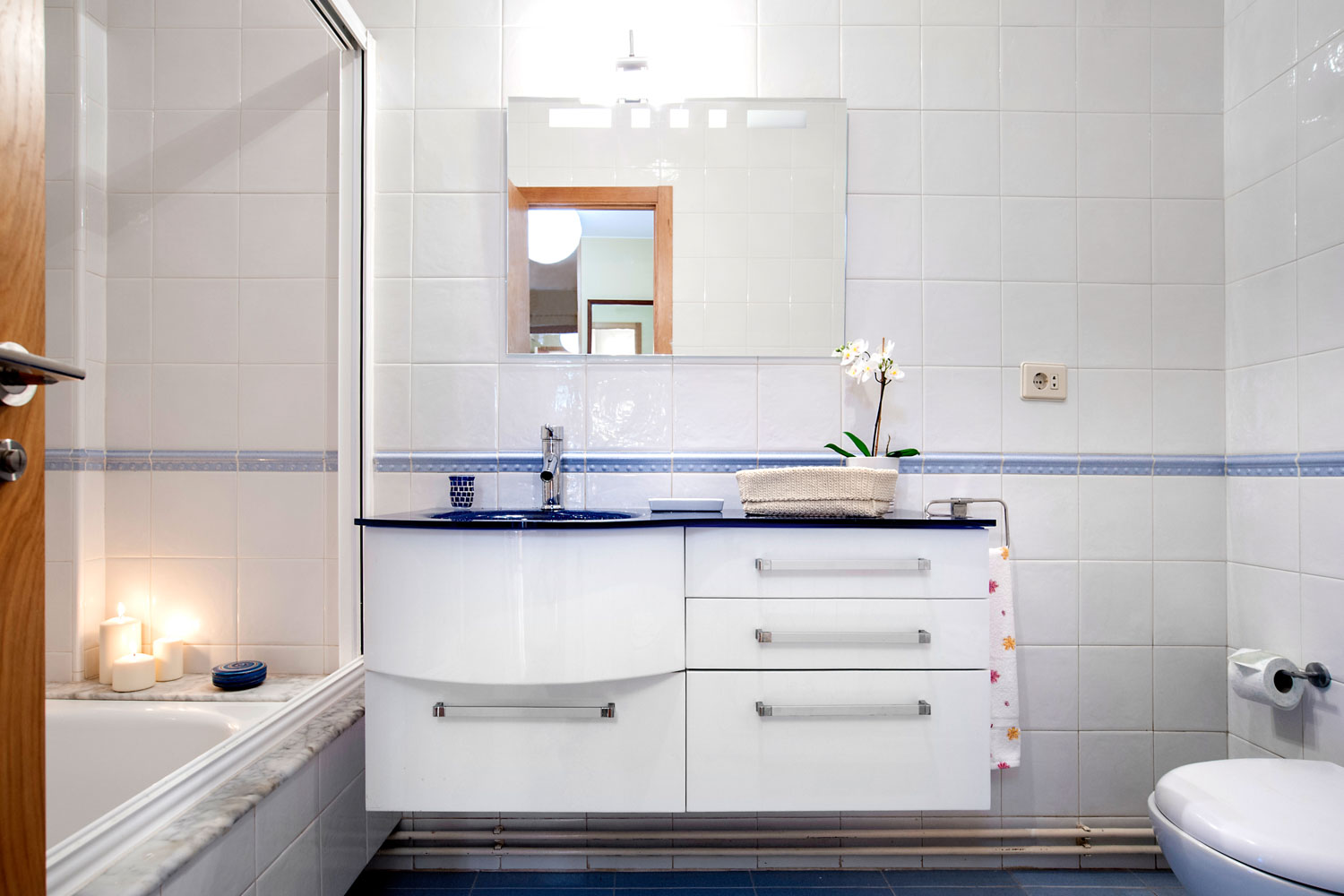 Detalle del mueble del baño lacado en blanco y lavabo en azul