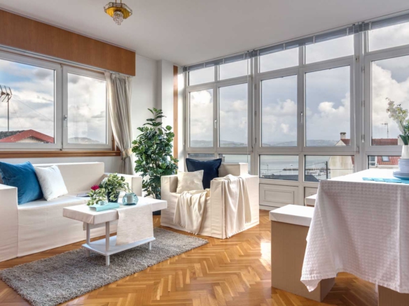 Salón con gran ventanal y vistas al mar