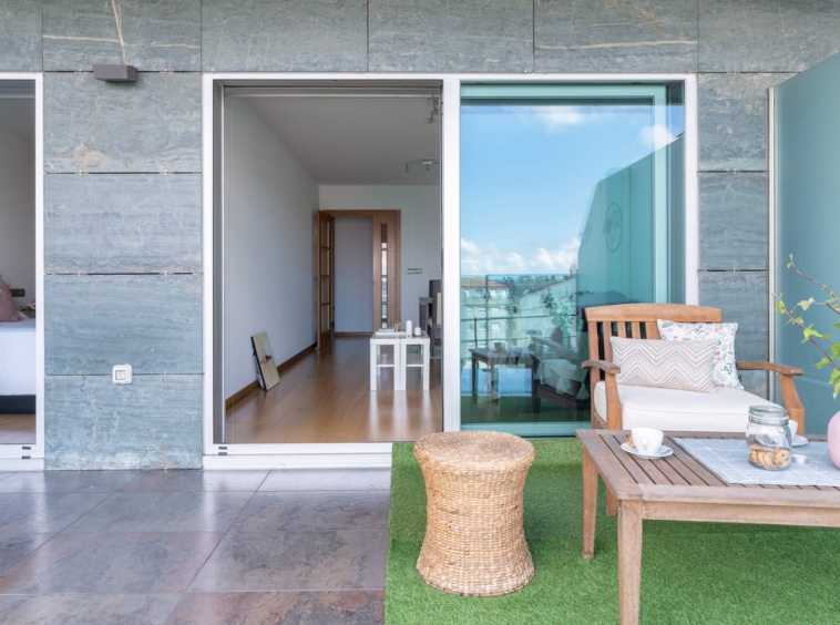 Fotografía de terraza en bajo Costa Dulce_césped artificial y mobiliario de jardín preaparado con home staging_acceso a dormitorio y salón comedor