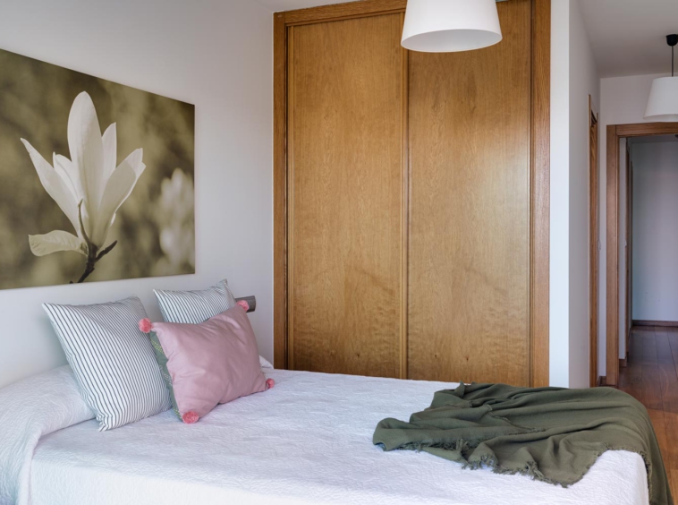 Dormitorio principal en bajo Costa Dulce Sada cojín rosa y manta verde_acceso y armario empotrado