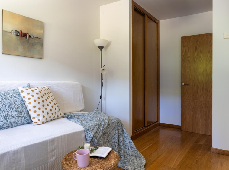 Dormitoirio individual en bajo Costa Dulce Sada_ cojjines verdes y blanco con puntos ocre_mesita de ratán_acceso y armario empotrado