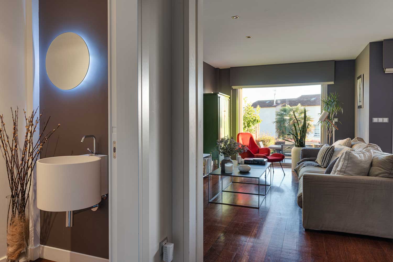 Conexión aseo minimalista con espejo retroiluminado y salón de diseño_unifamiliar Oleiros