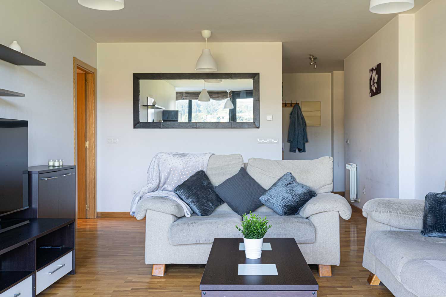 Salón preparado con Home Staging_ sofás beige y muebles oscuros_se aprecia la distribución de la vivienda