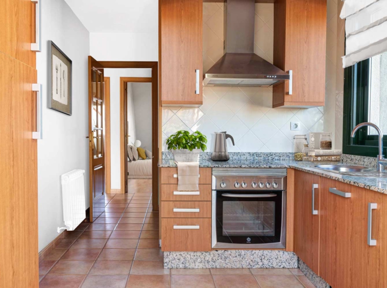 Cocina sencilla con Home Staging virtual_ Al fondo se ve la habtación a través de la puerta