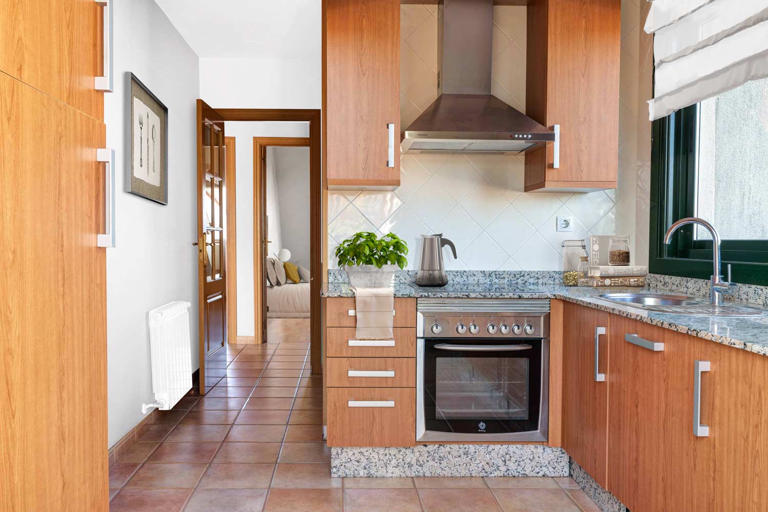 Cocina sencilla con Home Staging virtual_ Al fondo se ve la habtación a través de la puerta