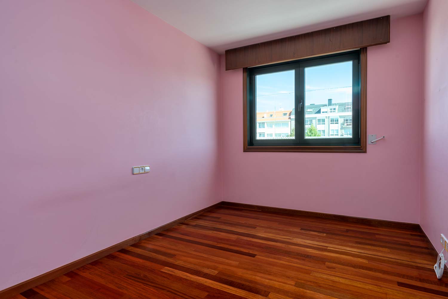Dormitorio rosa vacío en piso Betanzos con ventana de pvc verde_vistas despejadas