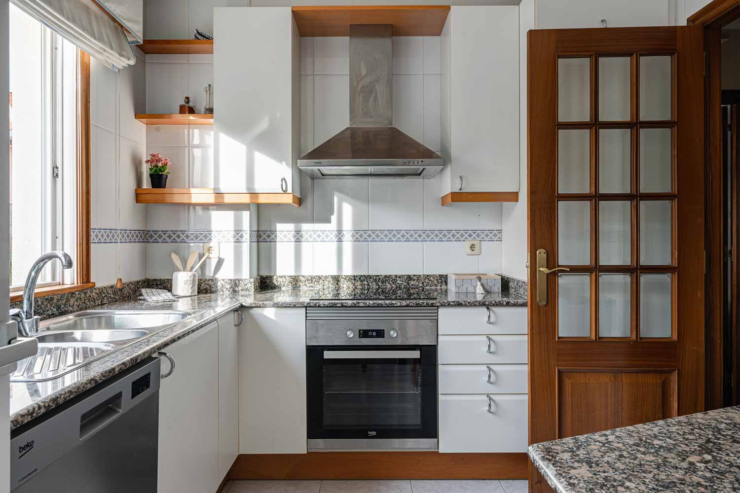 Cocina con muebles en blanco y electrodomésticos