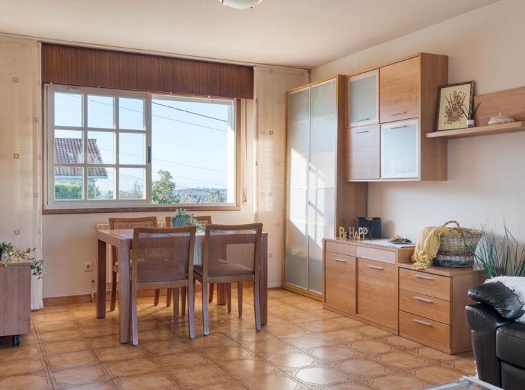 Comedor luminoso con muebles de madera y grandes ventanales en casa en venta en Sada, Inmobiliaria Morando.