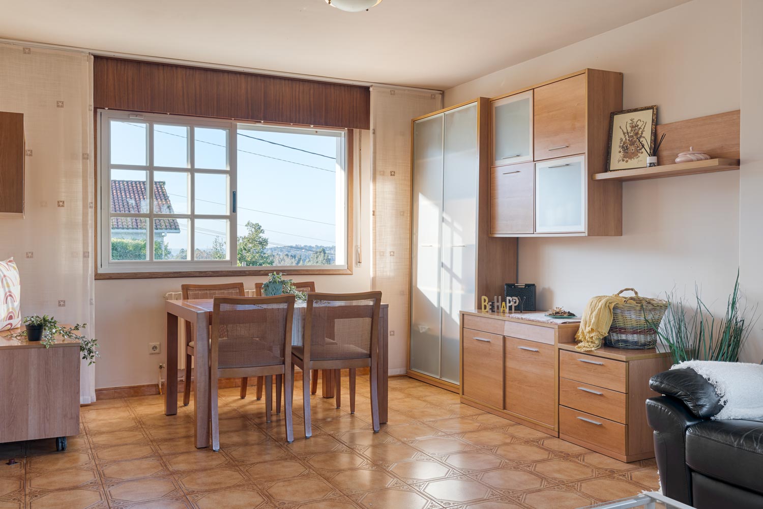 Comedor luminoso con muebles de madera y grandes ventanales en casa en venta en Sada, Inmobiliaria Morando.