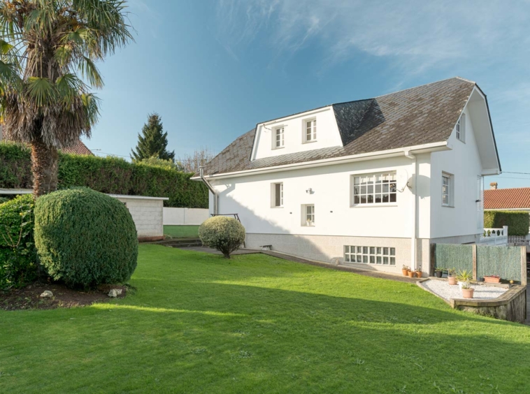 Casa con fachada blanca y jardín exterior en Sada, ideal para familias que buscan tranquilidad.