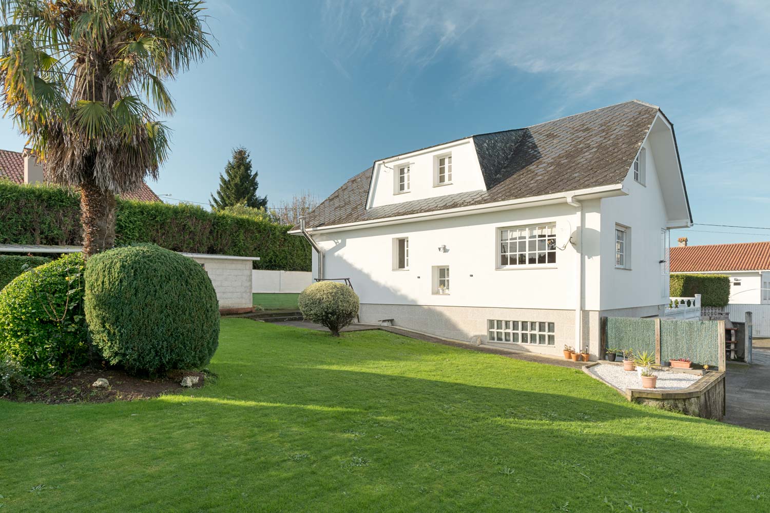 Casa con fachada blanca y jardín exterior en Sada, ideal para familias que buscan tranquilidad.